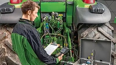 Mitarbeiter bei technischer Prüfung der Landmaschine