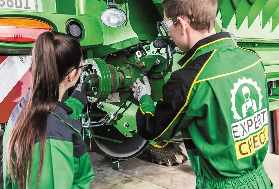 Mitarbeiter bei der Begutachtung einer Landmaschine