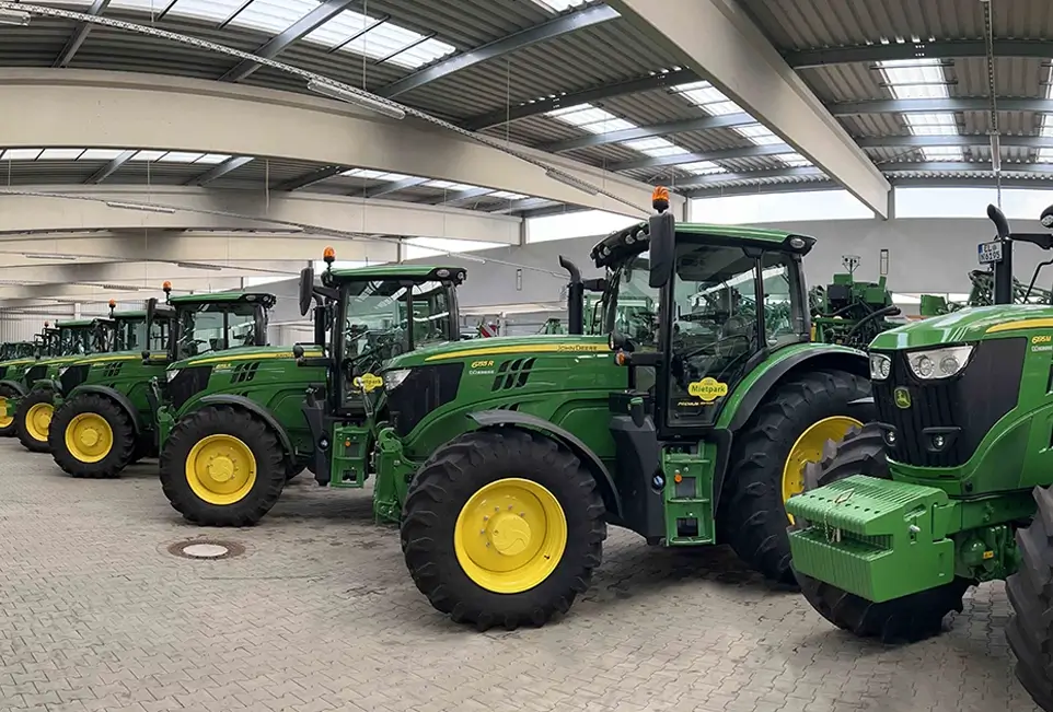 Grabrauchte John Deere Landmaschinen nebeneinander in Lagerhalle