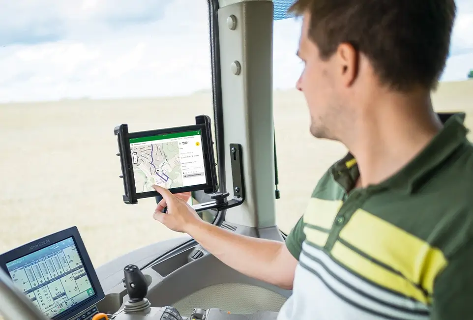Mann bedient Tablet in Fahrerkabine einer Landmaschine